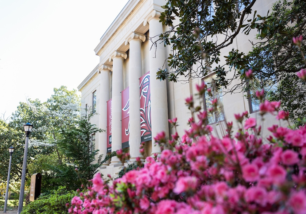 Building shown with flowers and USC flag. 