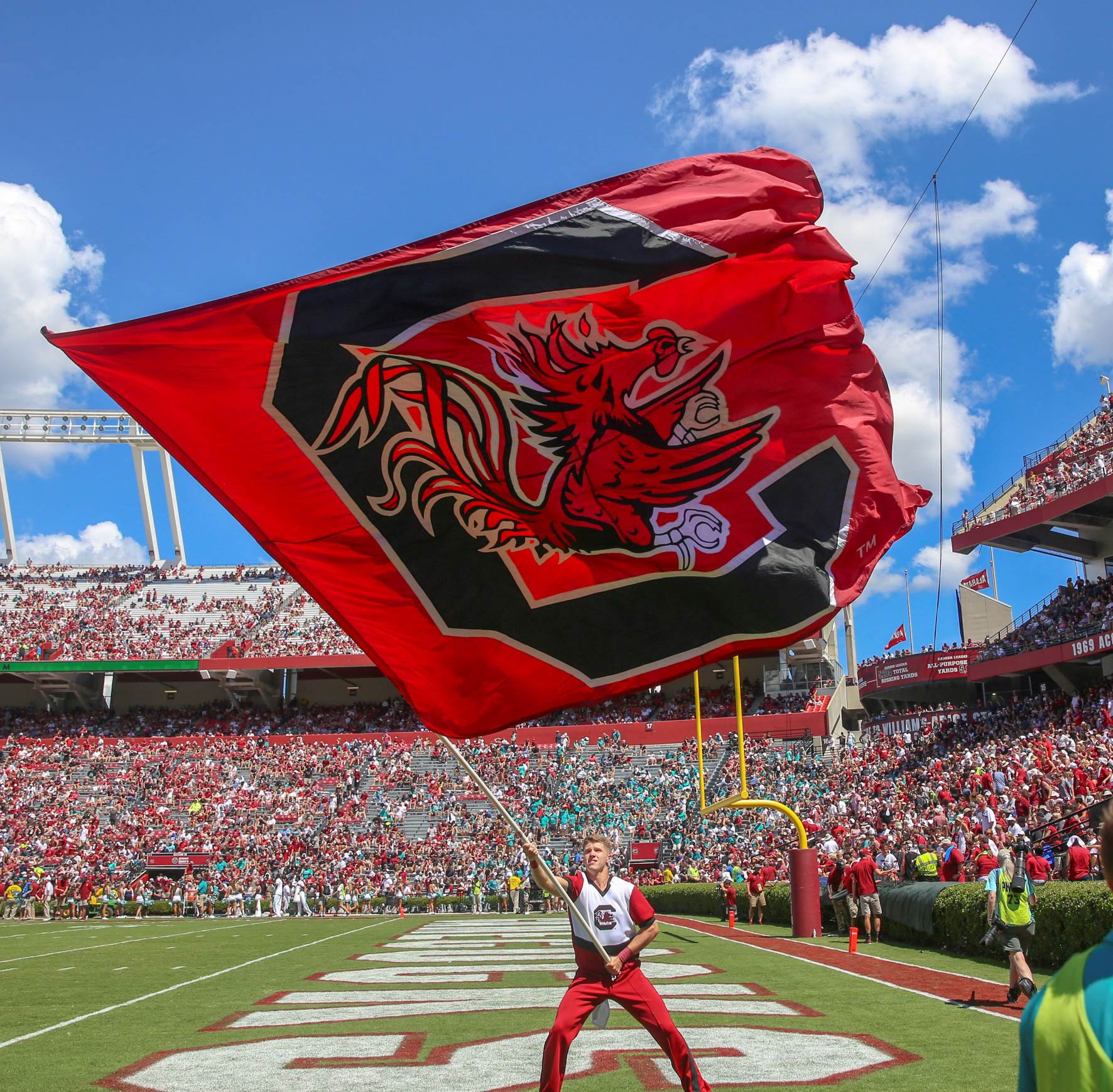 Cheerleader waving the gamecock flag at a football game