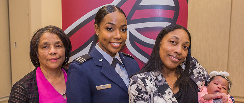 a family poses with their service member at a veterans alumni event