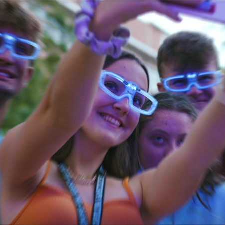 Students wearing glow in the dark glasses pose of a selfie