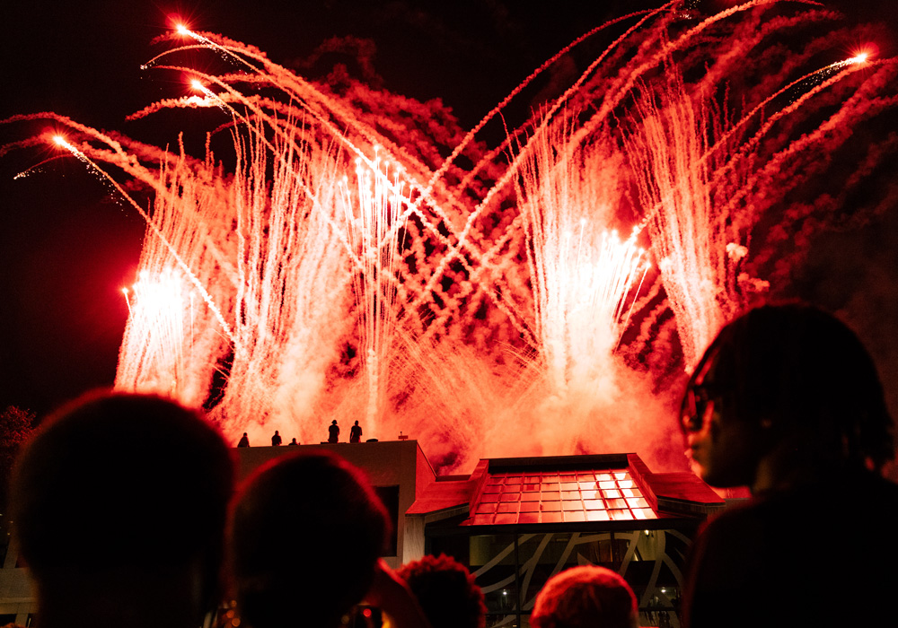 Students watch fireworks over the Russell House. 