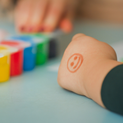 childs hand with a smiling stamp on it