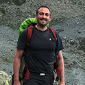 man outside with backpack on smiling