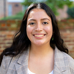 Photo of a woman with dark hair and a  standing outside 