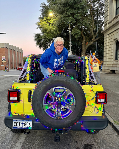 Sara Cunningham in the back of a vehicle at a Pride event wearing a Free Mom Hugs sweatshirt