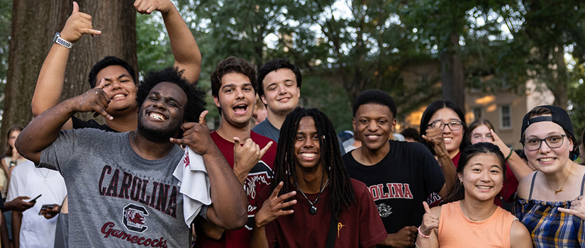 Happy students on the USC Horseshoe, some giving the Spurs Up sign