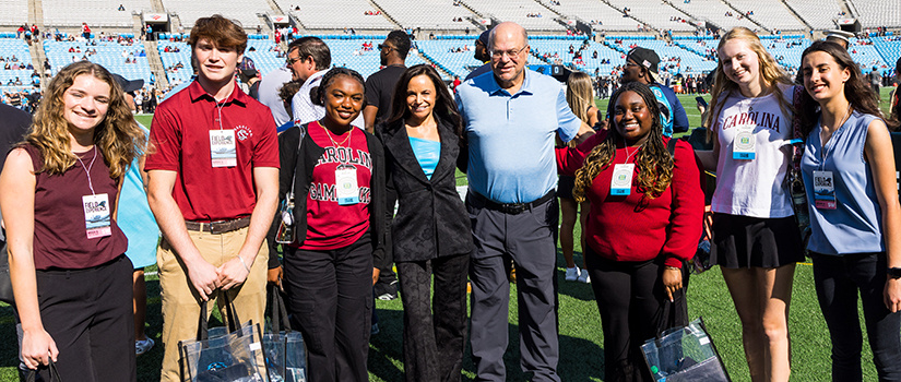 Tepper Scholars pose for a photo with David and Nicole Tepper while visiting for a Panthers game at Bank of America Stadium.
