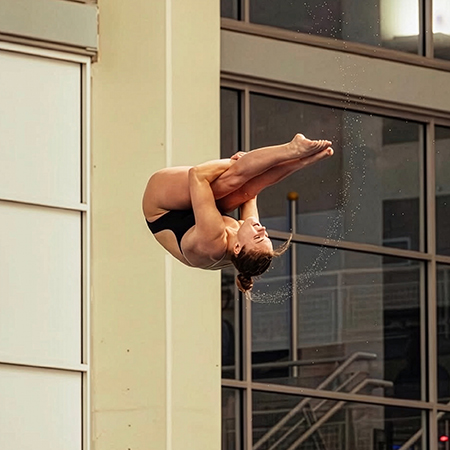 Sophie Verzyl performing a tight tuck dive midair during competition