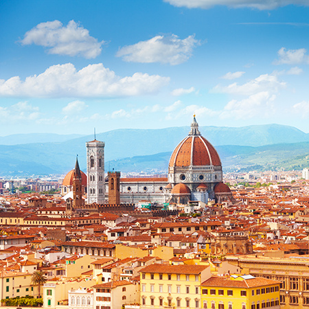 Panoramic view of Florence with the iconic red dome of the Cathedral of Santa Maria del Fiore (Duomo) rising above the terracotta rooftops.