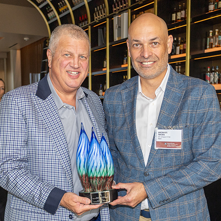 Mike Sagas stands with Derek Stevens holding the VILA.