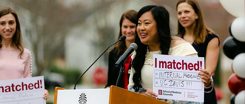 Excited student at podium shows her residency match