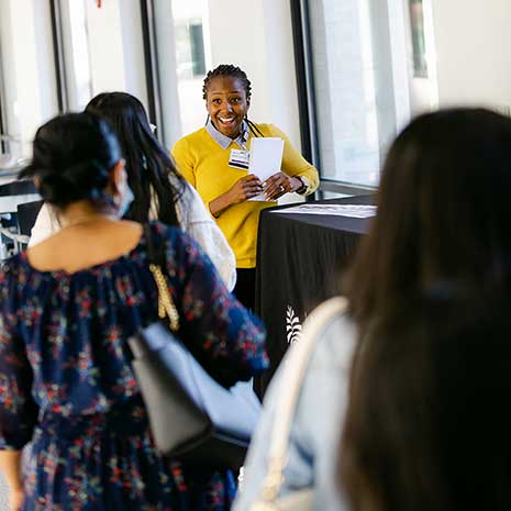 A staff member welcomes students to the program