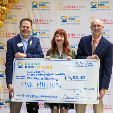 Three people holding an oversized check for $5M 