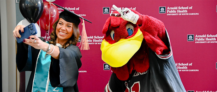 Alumni taking a pciture with Cocky 