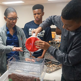 instructor and students perform an experiment at a summer camp