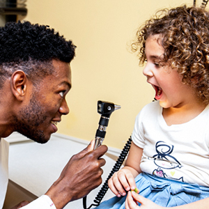 smiling_doctor_examines_young_patient