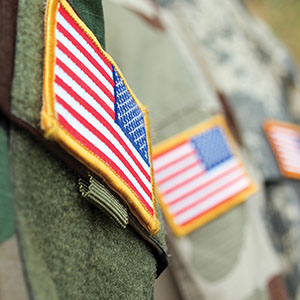 A series of American flag shoulder patches on camouflage uniforms