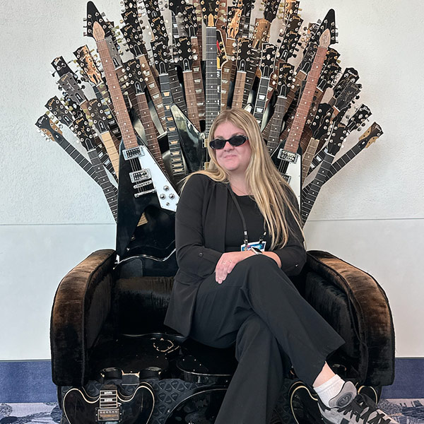 Catherine Pruitt sits among guitars at a business of music conference